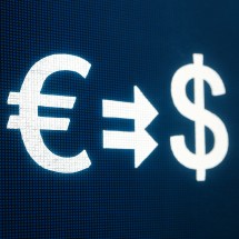 Euro and dollar symbols on a digital screen, representing currency transfers