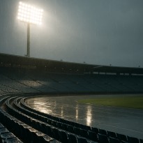 Floodlights shining on empty sports stadium during unexpected rain delay